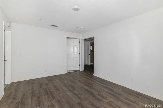 spare room featuring dark wood-type flooring