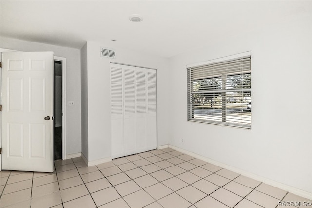 unfurnished bedroom featuring light tile patterned floors and a closet