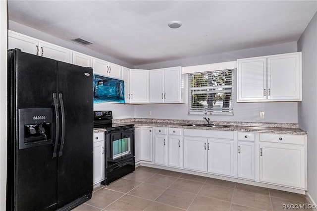 kitchen with black appliances, light tile patterned flooring, white cabinets, and sink