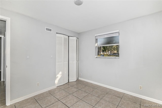 unfurnished bedroom featuring light tile patterned floors and a closet