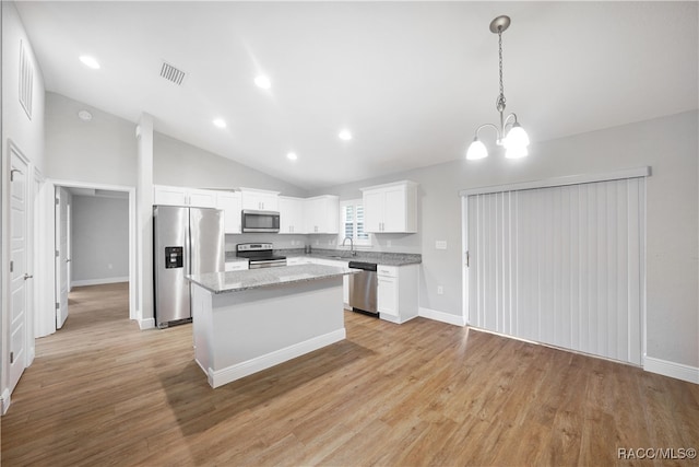 kitchen featuring pendant lighting, a center island, white cabinets, appliances with stainless steel finishes, and light hardwood / wood-style floors