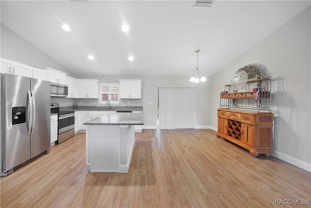 kitchen with appliances with stainless steel finishes, light hardwood / wood-style floors, white cabinetry, and a kitchen island