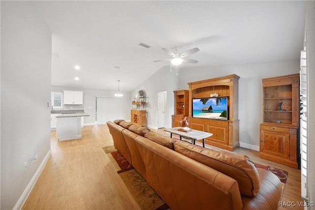 living room featuring ceiling fan, lofted ceiling, and light hardwood / wood-style flooring