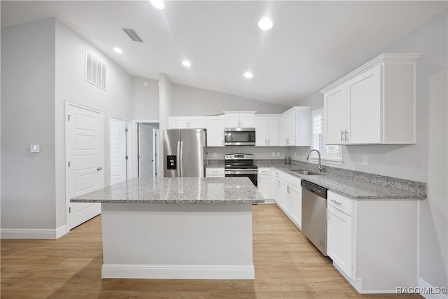 kitchen featuring a center island, stainless steel appliances, white cabinetry, and sink