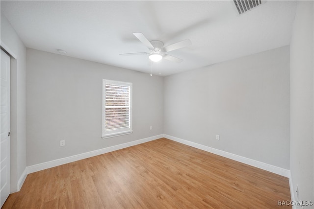 empty room with ceiling fan and light hardwood / wood-style flooring