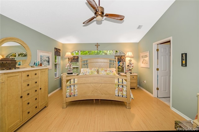 bedroom with ceiling fan, light hardwood / wood-style floors, and lofted ceiling