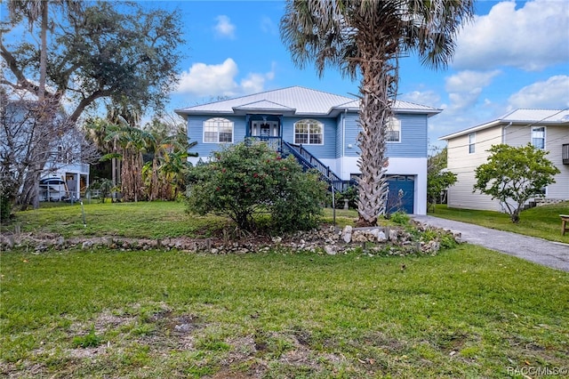 view of front of home with a garage and a front lawn