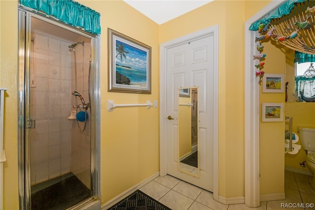 bathroom featuring tile patterned flooring, toilet, and walk in shower