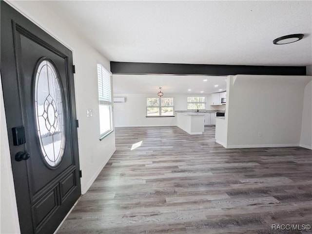 foyer entrance with hardwood / wood-style floors and a textured ceiling