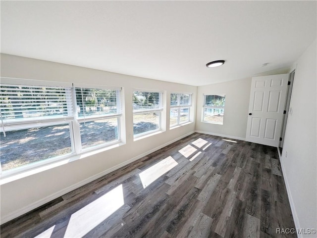 unfurnished room with dark hardwood / wood-style flooring