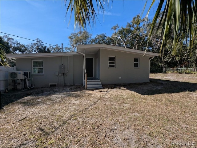 view of front of home with a front lawn and ac unit