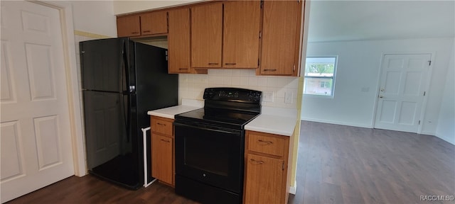 kitchen with backsplash, dark wood-type flooring, and black appliances