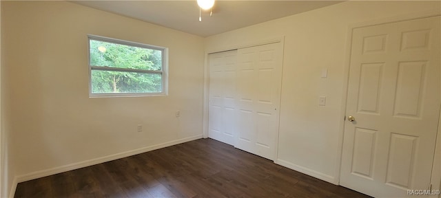 unfurnished bedroom featuring a closet and dark hardwood / wood-style flooring