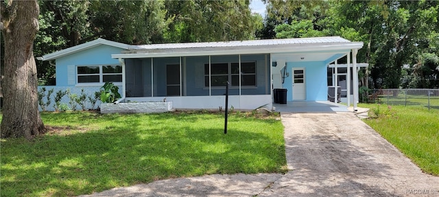 ranch-style home featuring a front yard and a carport