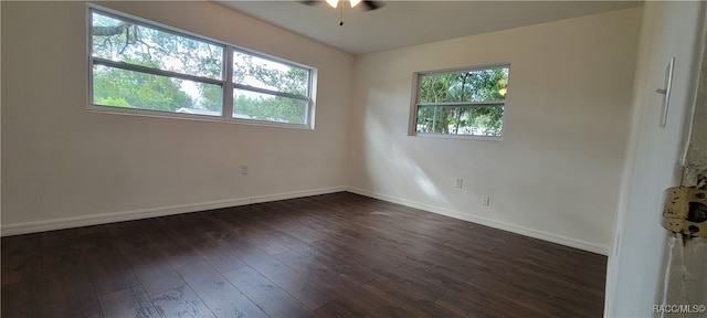 spare room with plenty of natural light, ceiling fan, and dark wood-type flooring