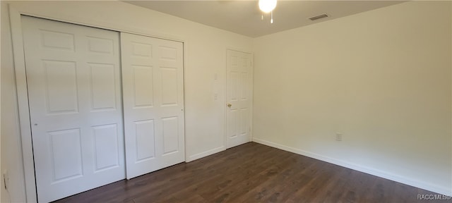 unfurnished bedroom featuring dark wood-type flooring and a closet