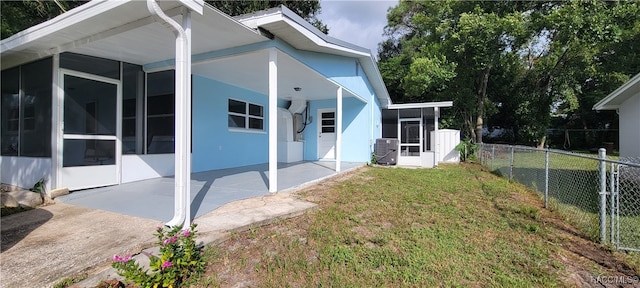 view of side of home featuring a patio area, a sunroom, and a yard