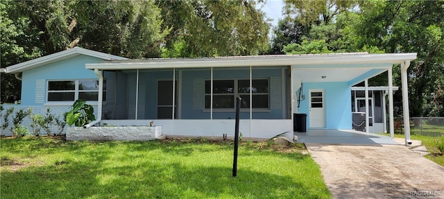 view of front of house featuring a front yard, a carport, and a sunroom