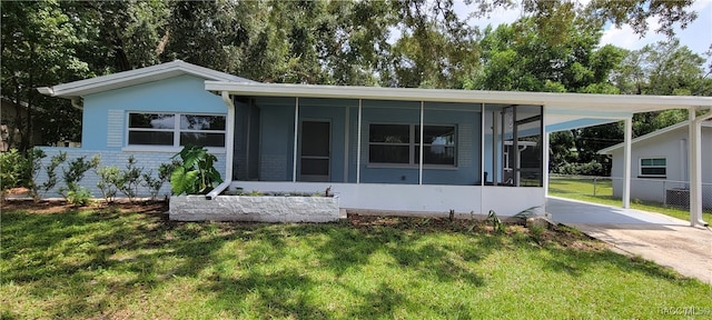 manufactured / mobile home with a sunroom, a front lawn, and a carport