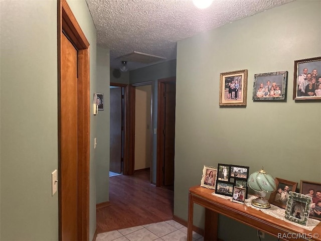 hallway featuring light tile patterned floors and a textured ceiling