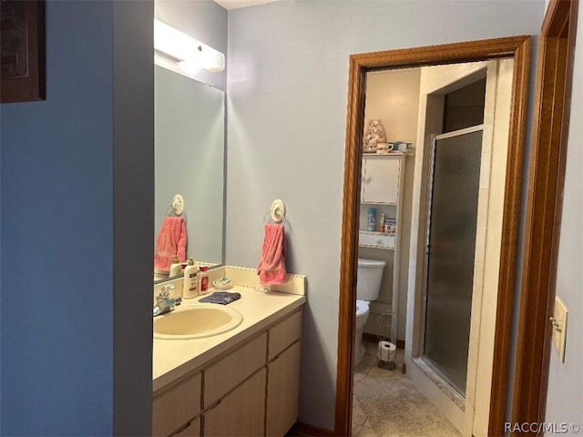 bathroom featuring vanity, a shower with shower door, and toilet