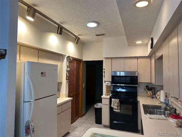 kitchen featuring track lighting, sink, a textured ceiling, black range with electric cooktop, and white fridge