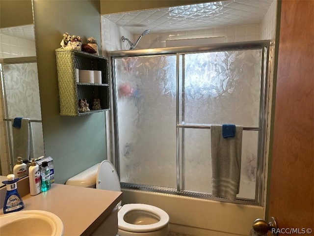 full bathroom with vanity, toilet, and enclosed tub / shower combo