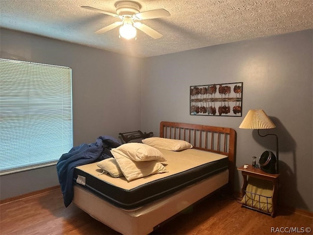 bedroom featuring hardwood / wood-style flooring, ceiling fan, and a textured ceiling