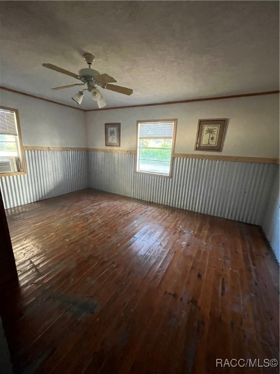 unfurnished room with a textured ceiling, ceiling fan, and dark wood-type flooring