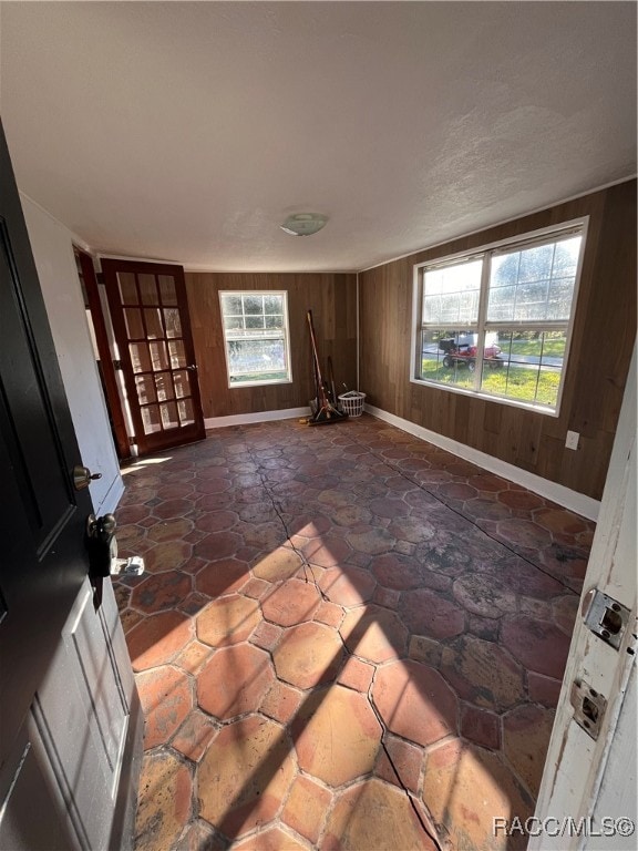 unfurnished room with wood walls