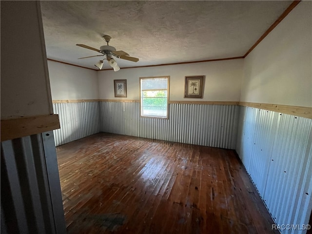 spare room featuring ornamental molding, a textured ceiling, ceiling fan, and dark wood-type flooring