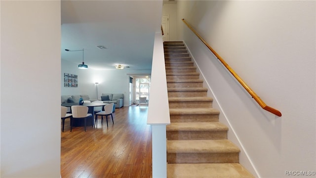 stairs featuring hardwood / wood-style flooring