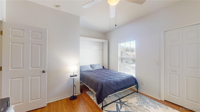 bedroom with hardwood / wood-style floors, ceiling fan, and a closet