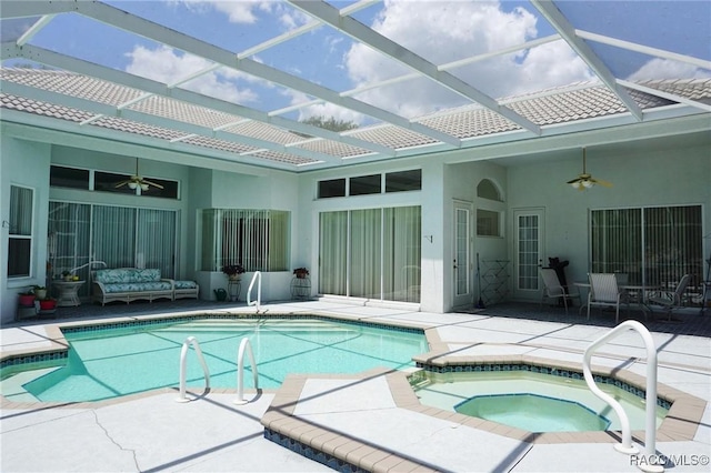 view of swimming pool featuring a patio area, ceiling fan, a pool with connected hot tub, and a lanai