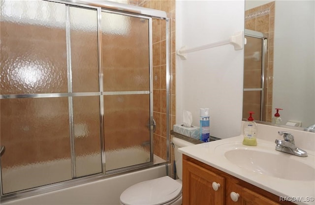full bath featuring toilet, vanity, and bath / shower combo with glass door