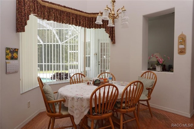 dining area with an inviting chandelier, plenty of natural light, and baseboards