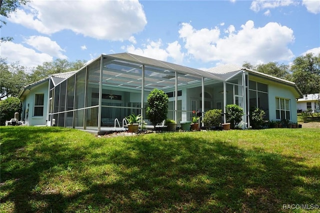 rear view of property featuring stucco siding, a lanai, and a lawn