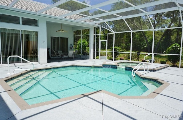 view of pool with a patio, a pool with connected hot tub, ceiling fan, and glass enclosure