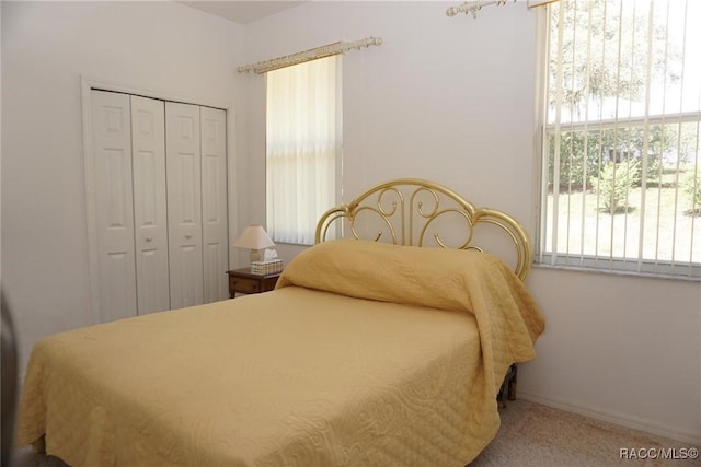 bedroom with a closet, baseboards, and carpet floors