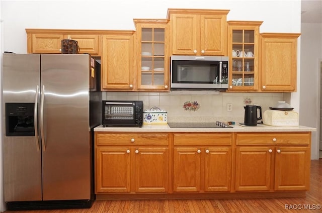 kitchen featuring stainless steel appliances, backsplash, and light countertops
