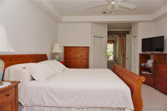 bedroom featuring light colored carpet, a closet, and a ceiling fan