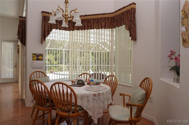 dining room with an inviting chandelier, baseboards, and wood finished floors