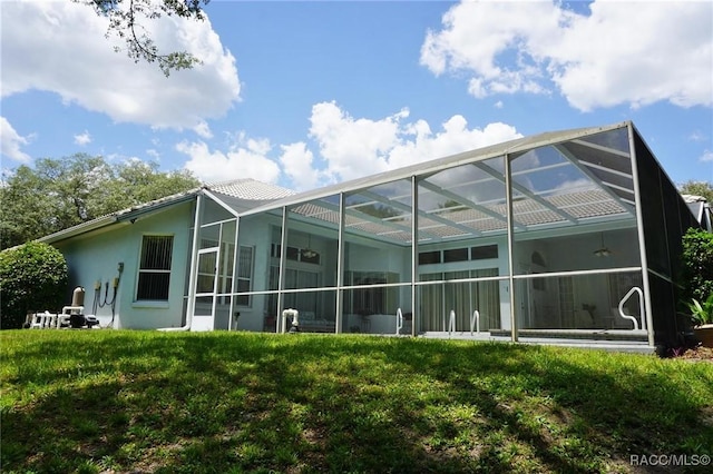 back of house with glass enclosure and stucco siding