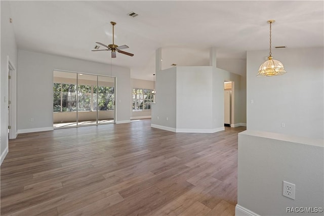 unfurnished living room featuring ceiling fan, vaulted ceiling, wood finished floors, and baseboards