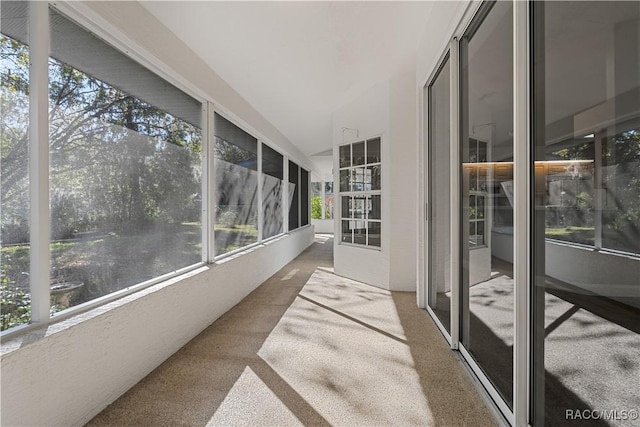 unfurnished sunroom with carpet and vaulted ceiling