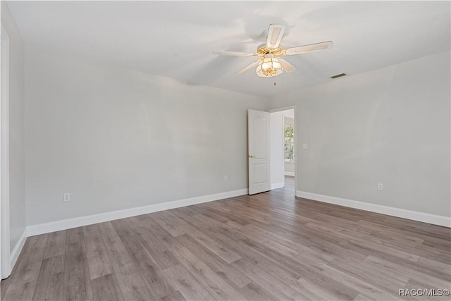 spare room with wood finished floors, ceiling fan, and baseboards