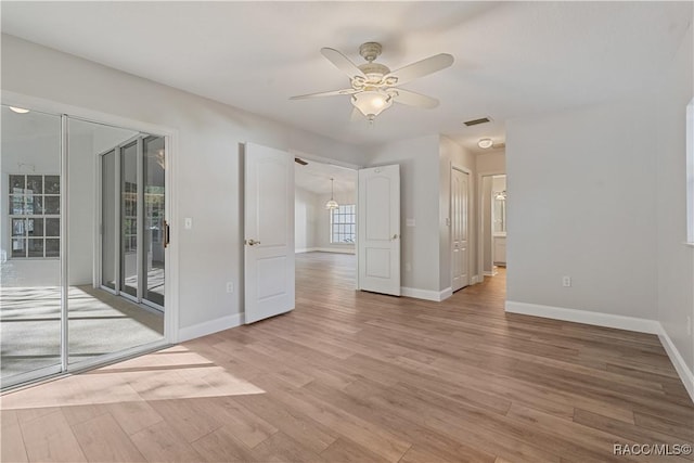 spare room featuring light wood-style floors, ceiling fan, and baseboards