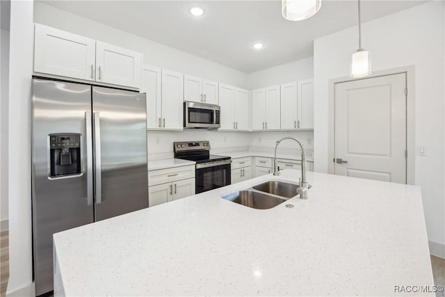 7820 N Sarazen Dr, Citrus Springs, FL 34434 - kitchen with stainless steel appliances, a sink, pendant lighting, white cabinetry, and light stone countertops