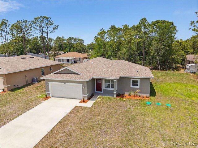 7820 N Sarazen Dr, Citrus Springs, FL 34434 - view of front of property with an attached garage, cooling unit, a shingled roof, a front lawn, and stucco siding