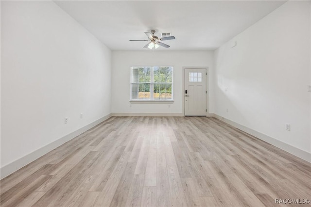 7820 N Sarazen Dr, Citrus Springs, FL 34434 - unfurnished living room with a ceiling fan, light wood-style floors, and baseboards